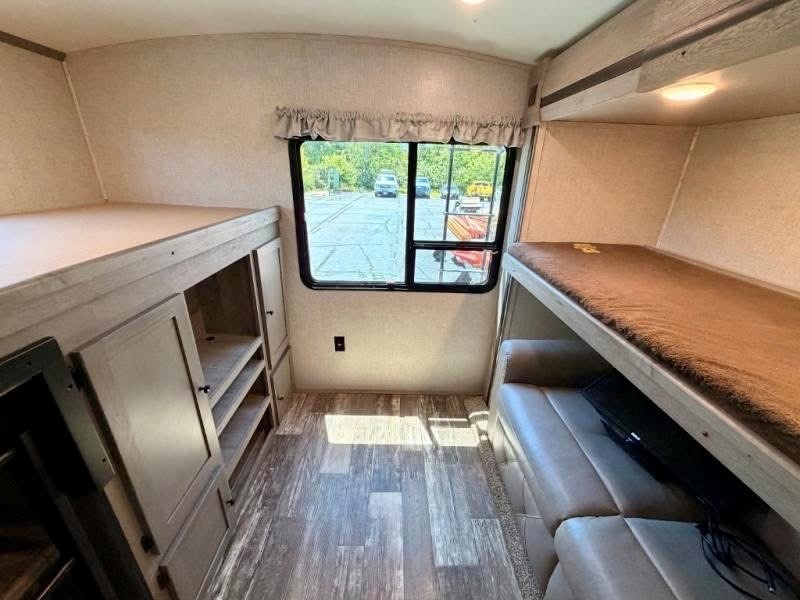 Bunk room with raised beds and a couch below